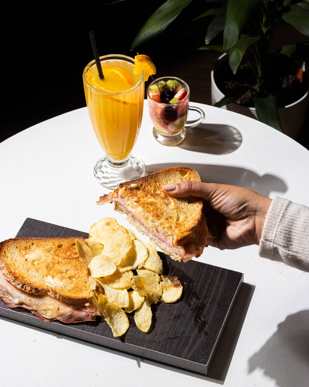 Sándwich tostado con chips y jugo naranja
