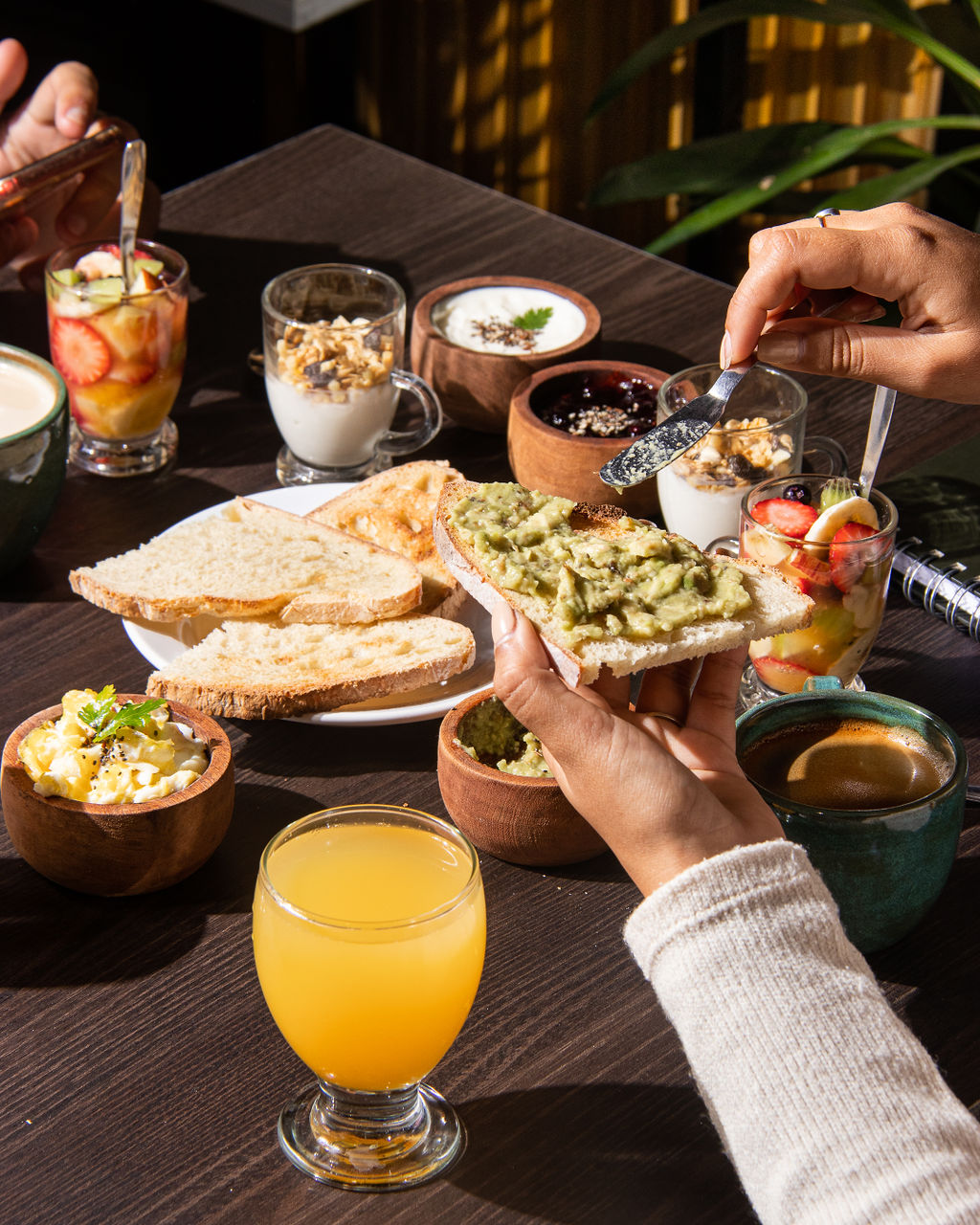 Mesa de desayuno completo con manos - avocado toast
