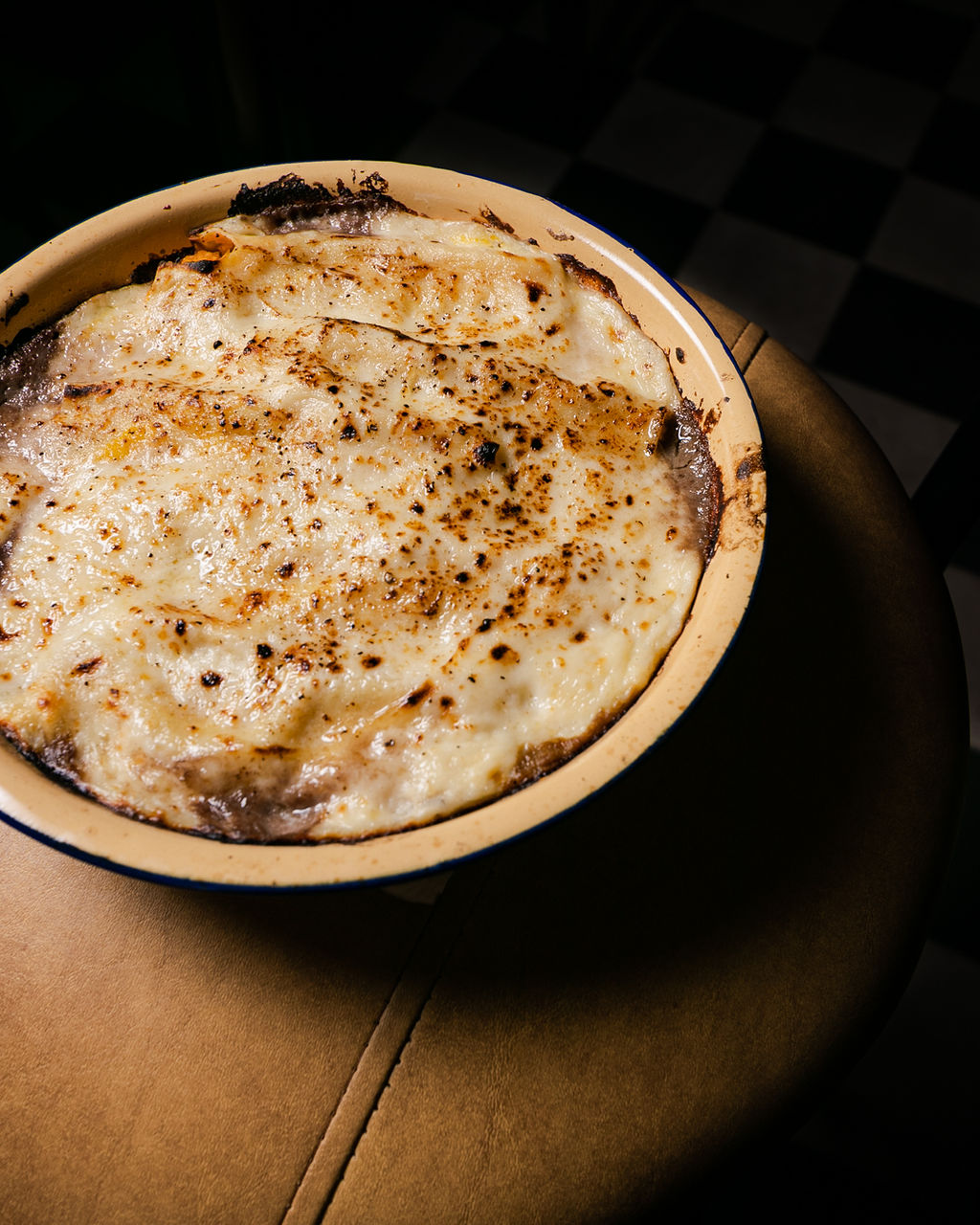 Gratinado en fuente sobre sofá de cuero