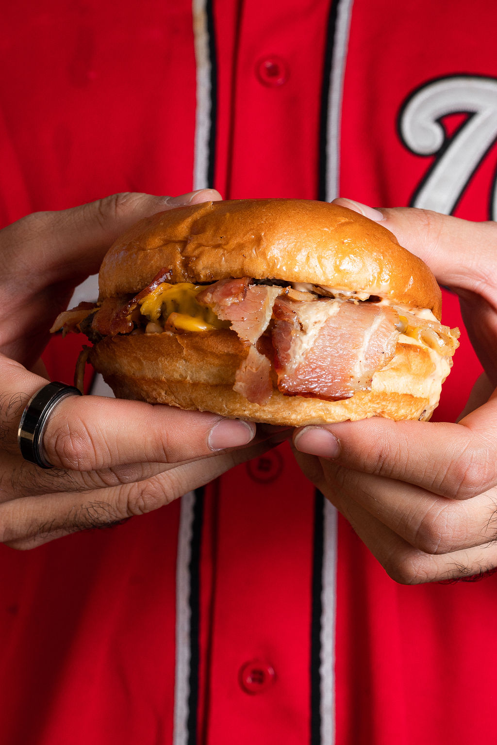 Burger sostenida en manos - fondo rojo camiseta